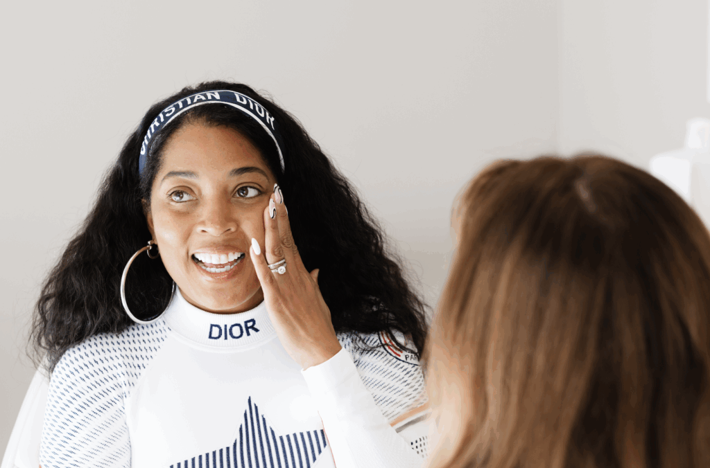 woman putting her hand to her face and smiling